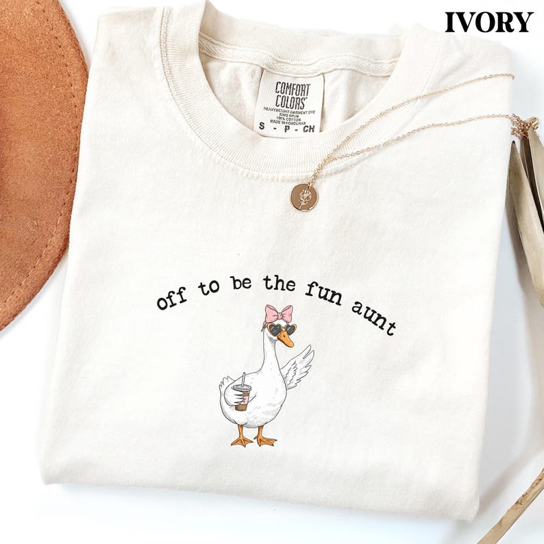 Stylish goose character with sunglasses and bow holding drink printed on graphic t shirt.