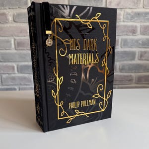 His Dark Materials (les 3 histoires en 1) par Philip Pullman ~ Livre relié, couverture rigide ~ Fait main, design original ~ Marque-page en velours attaché