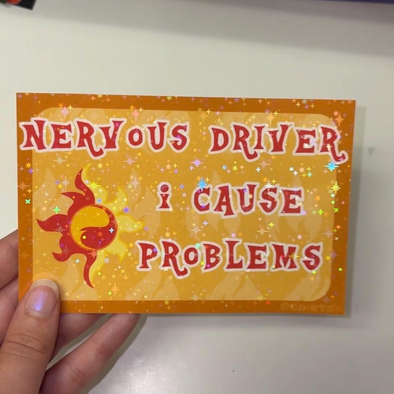 Puede incluir: Una pegatina rectangular con un acabado hologr&aacute;fico de estrellas sobre un fondo naranja. Presenta el texto rojo NERVOUS DRIVER I CAUSE PROBLEMS y un icono de sol estilizado en rojo y amarillo en el lado izquierdo del dise&ntilde;o.