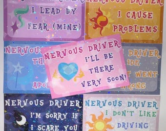 May include: A collection of seven rectangular stickers with holographic finishes, each featuring the text NERVOUS DRIVER and unique phrases like I LEAD BY FEAR, I CAUSE PROBLEMS, I'LL BE THERE VERY SOON, and I DON'T LIKE DRIVING AT NIGHT.