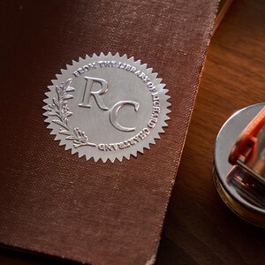 Peut inclure: Un sceau argenté en relief avec le texte "From the Library of Richard C. Gayley" et les initiales "RC" au centre.