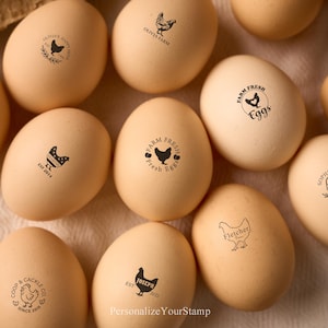 May include: A collection of beige eggs, each stamped with a black design featuring a chicken or the words "Farm Fresh Eggs." Some eggs have text like "Olivia's Farm" or "Joseph 2022."