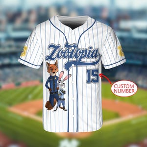May include: White baseball jersey with blue pinstripes, featuring the word "Zootopia" in blue script. The jersey has a cartoon image of Nick Wilde and Judy Hopps. The number "15" is on the front.