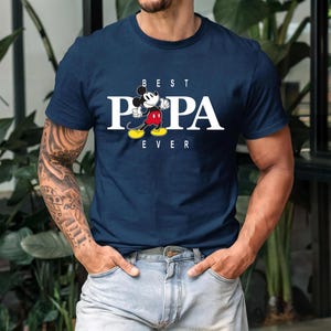 May include: A navy blue t-shirt with a white graphic of Mickey Mouse and the text "BEST PAPA EVER".