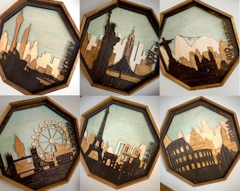 May include: Six wooden octagonal wall plaques with laser-cut city skylines. Each plaque features a different city: Sydney, New York, Rio de Janeiro, London, Paris, and Rome. The plaques have a light blue background with a dark brown wood frame.