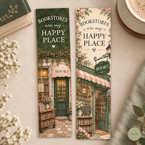May include: Two rectangular bookmarks featuring illustrations of bookstore storefronts. Both display the text "BOOKSTORES are my HAPPY PLACE". The left bookmark has a dark green background, while the right bookmark has a cream background with pink flowers.