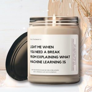 May include: A beige candle with a black lid and a white label that reads "Light me when you need a break from explaining what machine learning is. Infused with a dash of frustration and a whole lot of patience."