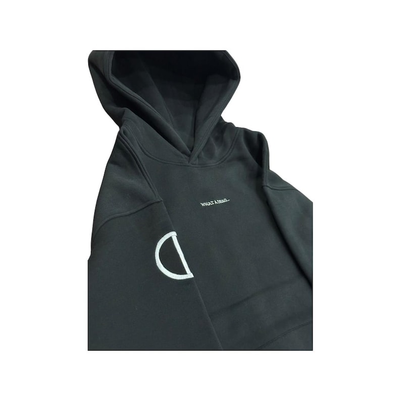 May include: Black hoodie with a hood and a white embroidered "D" on the left sleeve. The text "WHAT A..." is printed in white on the chest. The hoodie is made of a soft material.