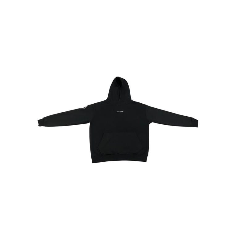 May include: Black hoodie with a hood and a front pocket. The hoodie has long sleeves and a small logo on the left sleeve. A small white text is printed on the chest. The hoodie is spread out on a white background.