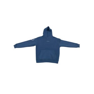 May include: A blue hoodie with a front pocket and a hood. The hoodie has a white circular design on the left sleeve and small white text on the chest. The hoodie is made of a soft material.