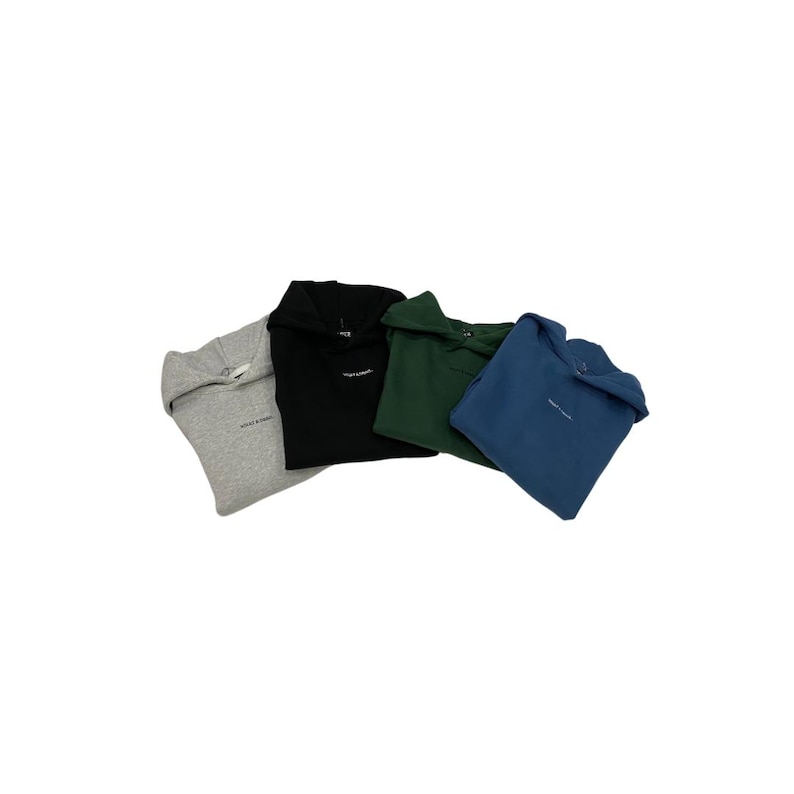 May include: Four hooded sweatshirts in various colors: gray, black, dark green, and blue. Each sweatshirt has a small, white logo on the chest. The sweatshirts are made of a soft material and are folded.