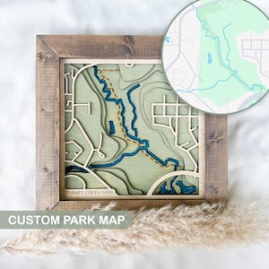 May include: A wooden framed map of Turkey Creek Park with a 3D effect. The map is green and blue with a brown frame. The text "CUSTOM PARK MAP" is below the map.