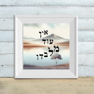 May include: A framed print with a watercolor landscape scene. The print features a mountain range, a lake, and a single tree. The text "איה עוד לך בבדד" is written in Hebrew in black lettering.