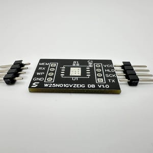 Może przedstawiać: Czarna płytka drukowana z układem scalonym W25N01GVZEIG DB V1.0 i złączami. Płytka jest opisana jako MEM, RX, WP, GND, VCC, HLD, SCK i TX.