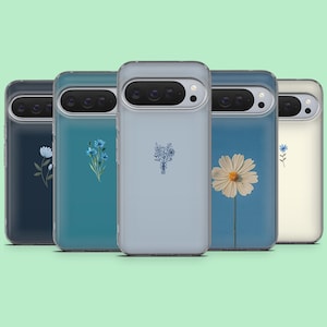 May include: A collection of five phone cases with floral designs. The cases are in various colors, including navy, teal, and light blue. Each case features a different floral illustration, such as a daisy or a bouquet of flowers. The cases are made of a clear material.