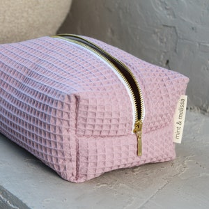 Close-up of the  gold metal zipper pull on the eco-friendly makeup bag, highlighting its stylish and functional design.