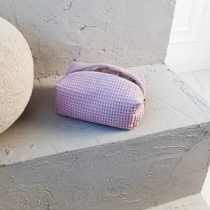 Handmade waffle-textured minimalist makeup bag with zipper, eco-friendly toiletry pouch in dusty rose  tones.