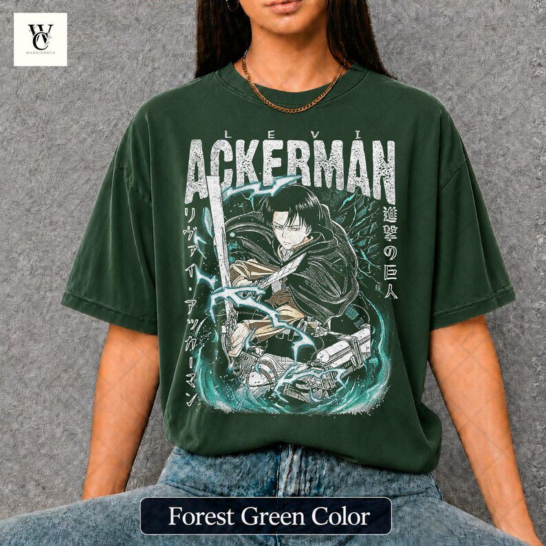 Pu&ograve; includere: T-shirt verde foresta con grafica di un personaggio con una spada, il nome "ACKERMAN" in bianco e testo giapponese. Il design include effetti di fulmini e acqua. La maglietta ha una vestibilit&agrave; ampia.
