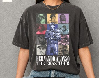 May include: A dark gray t-shirt featuring a grid of colorful portraits and the text "FERNANDO ALONSO THE ERAS TOUR." The shirt is pepper color and has a vintage look.