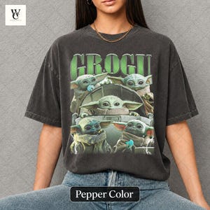May include: Pepper color t-shirt featuring a graphic of Grogu from The Mandalorian. The design includes multiple images of Grogu, with the name "GROGU" in green block letters above. The shirt is a relaxed fit.