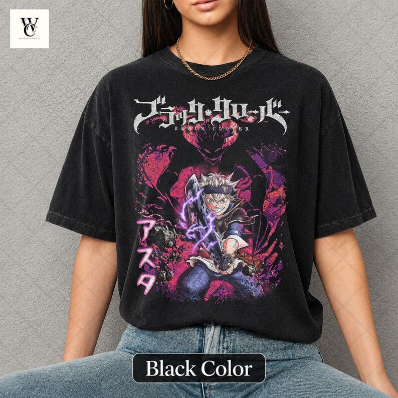 Może przedstawiać: Czarny t-shirt z grafiką z anime Black Clover. Projekt zawiera japoński tekst i ilustrację postaci z fioletowymi i r&oacute;żowymi akcentami. Koszulka ma wygląd vintage.