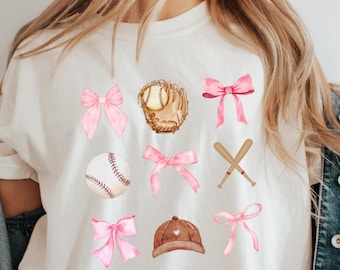 May include: White t-shirt with pink bows, a baseball, a baseball glove, bats, and a baseball cap.