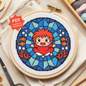 May include: A cross-stitch embroidery featuring a cartoon character with red hair and a red dress, surrounded by blue stained-glass-style patterns, orange fish, and coral. The design is set in a wooden embroidery hoop. Text on the image reads "PDF to print or download."