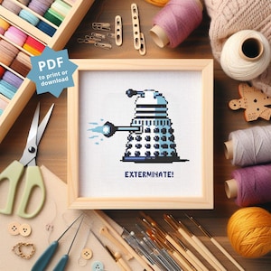 May include: A cross-stitch pattern featuring a blue and white pixelated image of a Dalek from the Doctor Who television series. The Dalek is holding a weapon and the text "Exterminate!" is below the image.