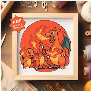 May include: A framed cross-stitch featuring a group of orange and yellow cartoon characters against a fiery orange background. The characters are in front of a large orange sun. The frame is made of light-colored wood. The text "PDF to print or download" is in the upper left corner.