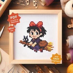 May include: Cross-stitch pattern of a cartoon witch with a black cat on a broom, framed in a light wood square. The witch has a red bow and is wearing a purple dress. Text on the image says "PDF to print or download", "Mini size", and "level EASY beginners".