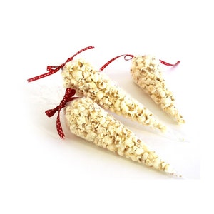May include: Three clear plastic cones filled with popcorn, tied with red and white polka dot ribbon.