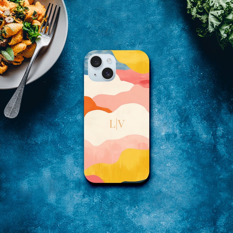 a phone case sitting next to a plate of food