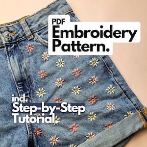 Könnte beinhalten: Blaue Jeansshorts mit gestickten Gänseblümchen in Rosa, Gelb und Weiß. Die Shorts haben einen umgeschlagenen Saum und einen Knopfverschluss. Der Text auf dem Bild lautet "PDF Embroidery Pattern" und "Step-by-Step Tutorial."