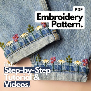 Könnte beinhalten: Hellblaue Jeans mit gestickten Blumenmustern an den Manschetten. Die Stickerei zeigt weiße Gänseblümchen, rosa Blüten und grüne Blätter. Der Text auf dem Bild lautet "Stickmuster" und "Schritt-für-Schritt-Anleitung & Videos."