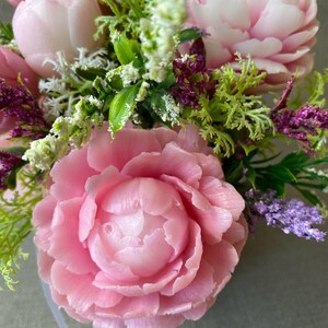May include: A bouquet of pink soap flowers with green leaves and purple accents. The flowers are arranged in a clear vase. The text "Soap Bouquets UK" is visible at the bottom of the image.