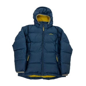 Puede incluir: Una chaqueta acolchada de color azul oscuro con capucha, que presenta un forro interior amarillo brillante y tiradores de cremallera amarillos a juego. El nombre de la marca Kathmandu está bordado en amarillo en el pecho izquierdo. Tiene mangas largas.