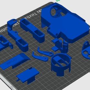 Könnte beinhalten: Ein Satz von 10 blauen 3D-gedruckten Kunststoffteilen. Die Teile sind in verschiedenen Formen und Größen, darunter ein großes rechteckiges Teil mit einem Loch in der Mitte, ein kleineres rechteckiges Teil mit abgerundeter Kante und ein kreisförmiges Teil mit einem Loch in der Mitte.