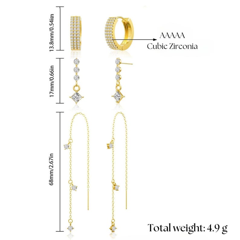 May include: A set of three pairs of gold earrings with cubic zirconia stones. The earrings include a pair of hoops, a pair of drop earrings, and a pair of long chain earrings.