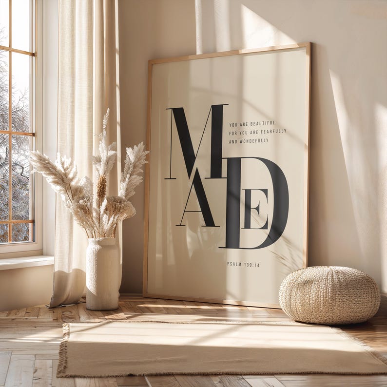 Oversized beige and black fearfully and wonderfully made Psalm 139:14 MADE typography poster in wooden frame leaning against sunlit wall with dried pampas grass, Christian scripture wall art digital download