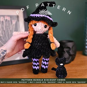 May include: A crocheted witch doll with orange plaits, a black dress, and a matching hat with purple trim. A small black cat sits nearby. The image includes the text "PDF PATTERN".