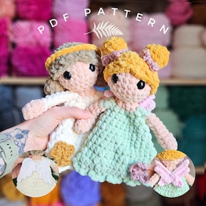 May include: Two handmade crochet dolls with yarn hair and dresses. One doll wears a white dress, the other a green dress. The dolls have black eyes and are held in front of a background of colorful yarn. The text "PDF PATTERN" is at the top.