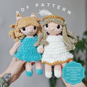 May include: Two handmade crochet dolls with yarn hair and dresses. One doll wears a blue dress, the other a white dress with gold trim. The dolls have black eyes and pink skin. The words "PDF PATTERN" are at the top.