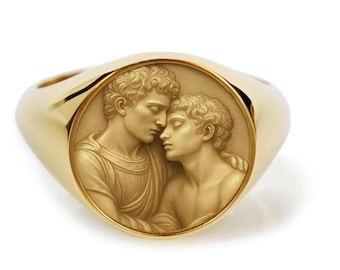 May include: A gold signet ring featuring a circular inset with a detailed relief carving of two figures with curly hair leaning toward each other. The polished gold band surrounds the central medallion, which displays a matte, light-toned finish.