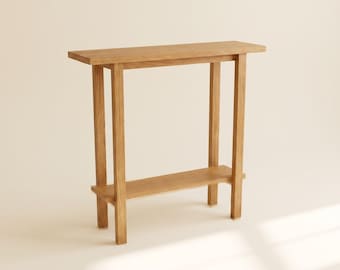 May include: A light brown wooden console table featuring a rectangular top surface, four straight vertical legs, and a single lower shelf positioned between the legs. The furniture piece is constructed from natural wood with a visible grain pattern.