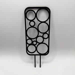 May include: Black metal decorative garden stake with a geometric design of overlapping circles. The stake is about 12 inches tall and has two prongs at the bottom.