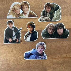 May include: A set of seven stickers featuring various images of a character from the Lord of the Rings movie franchise. The stickers are printed on white paper with a glossy finish.