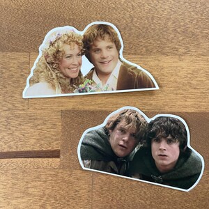 May include: Two stickers featuring scenes from The Lord of the Rings. The first sticker shows a wedding scene with a woman in a white dress and a man in a brown suit. The second sticker shows two men in a forest setting, one with a worried expression and the other with a concerned look.