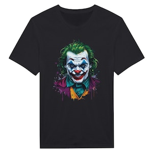 Può includere: Maglietta nera con una grafica colorata del Joker del film "Joker". Il Joker è raffigurato con i capelli verdi, la faccia dipinta di bianco e un sorriso rosso.