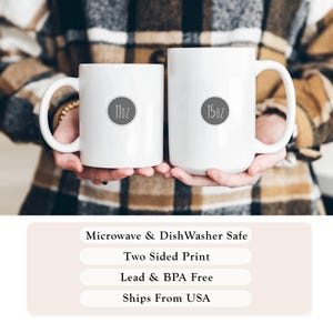 May include: Two white ceramic mugs, one labeled "11oz" and the other "15oz", are held in front of a plaid background. The mugs have large handles. Text at the bottom indicates they are microwave and dishwasher safe, with a two-sided print, and lead and BPA free.
