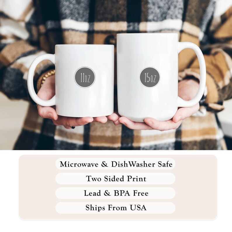 May include: Two white ceramic mugs, one labeled "11oz" and the other "15oz", are held in front of a plaid background. The mugs have large handles. Text at the bottom indicates they are microwave and dishwasher safe, with a two-sided print, and lead and BPA free.